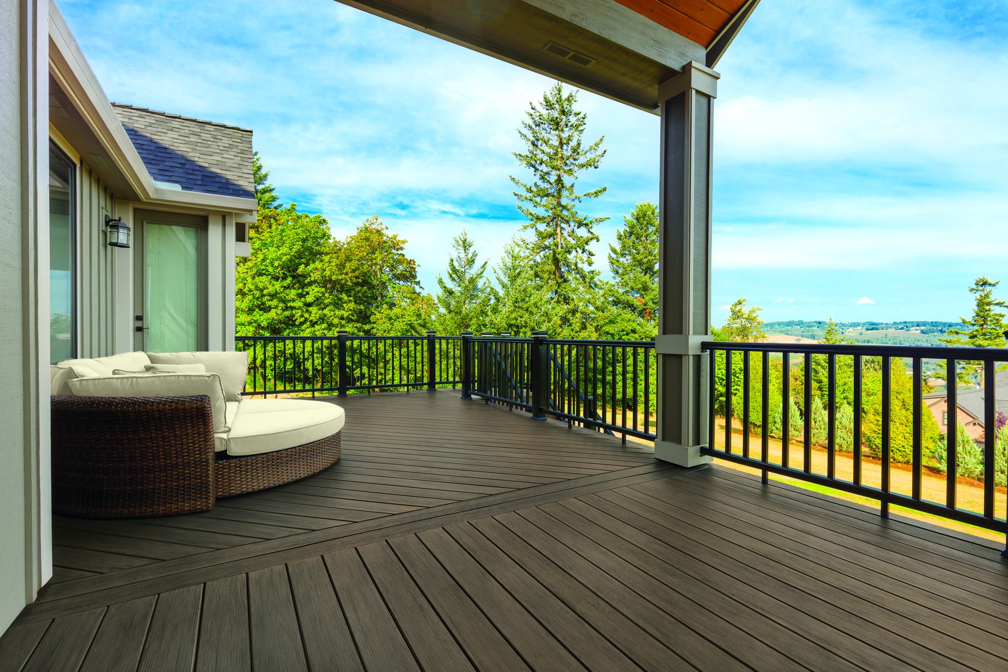 TimberTech Prime+ composite deck in Dark Cocoa with covered seating area and black metal railing