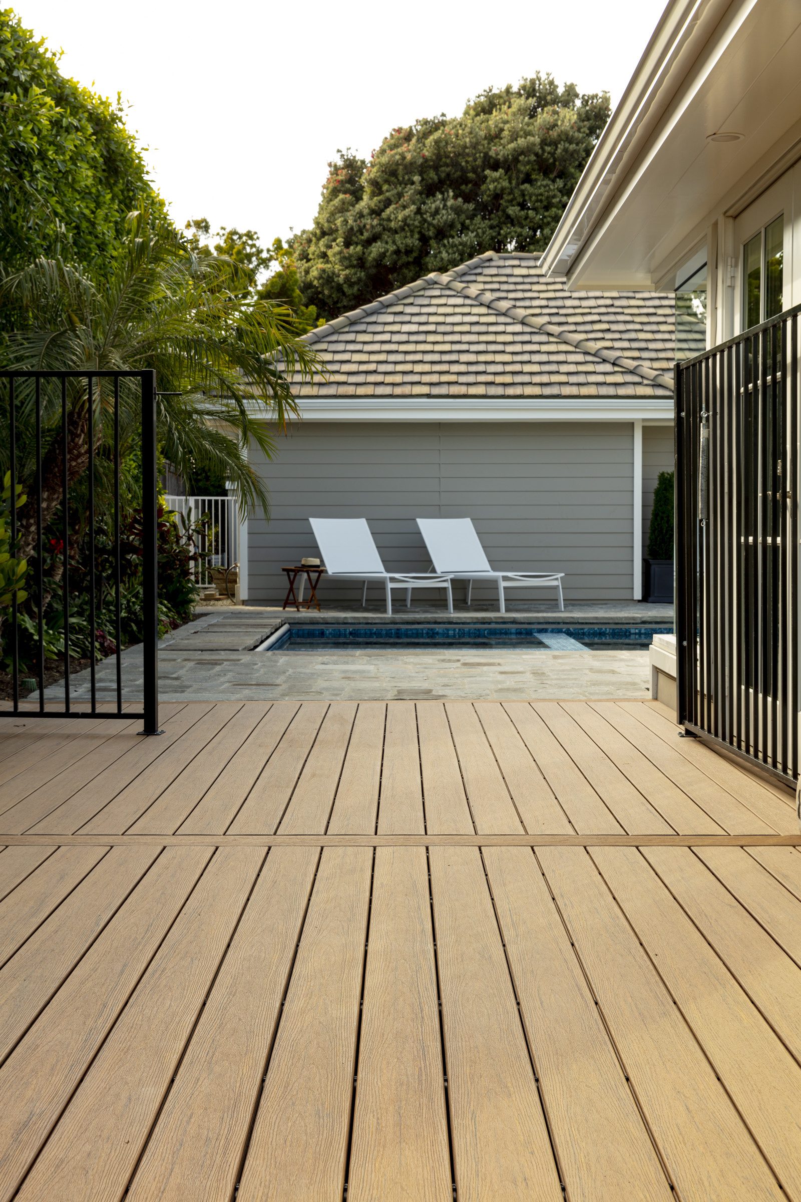 Poolside TimberTech Reserve composite deck in Antique Leather with lounge chairs